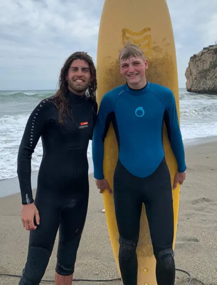 Equipo Isobaras con tabla de surf en la playa del Rincón