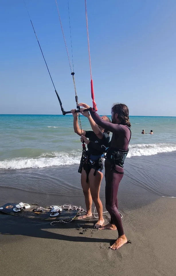 Instructor enseñando el manejo del ala y la barra antes de entrar al agua