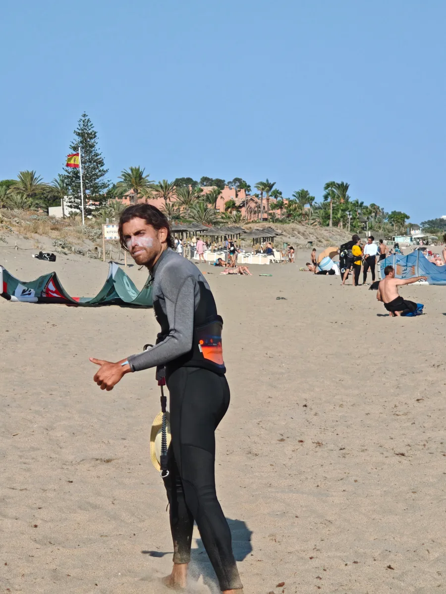 Instructor de kitesurf con neopreno listo para la sesión en la playa